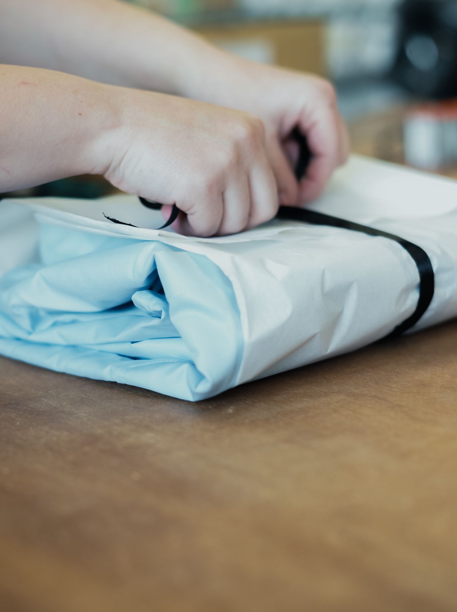 Hand-packing apparel in paper with a ribbon
